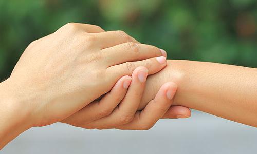 Photo of two people holding hands